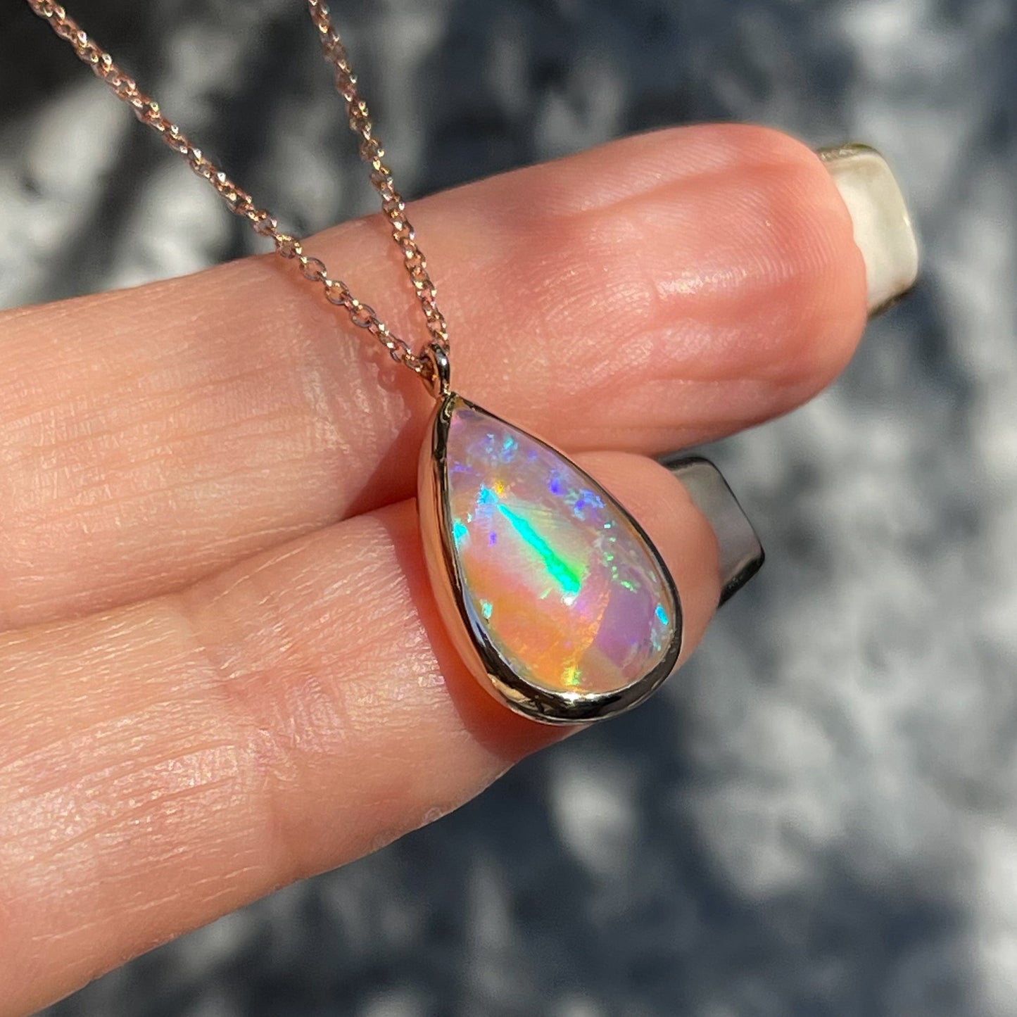An Australian Opal Necklace by NIXIN Jewelry. The pink opal rests in a rose gold bezel setting.