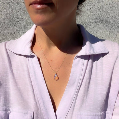 Model wearing an Australian Opal Necklace by NIXIN Jewelry to show scale. Crystal Opal pendant necklace in 14k rose gold.
