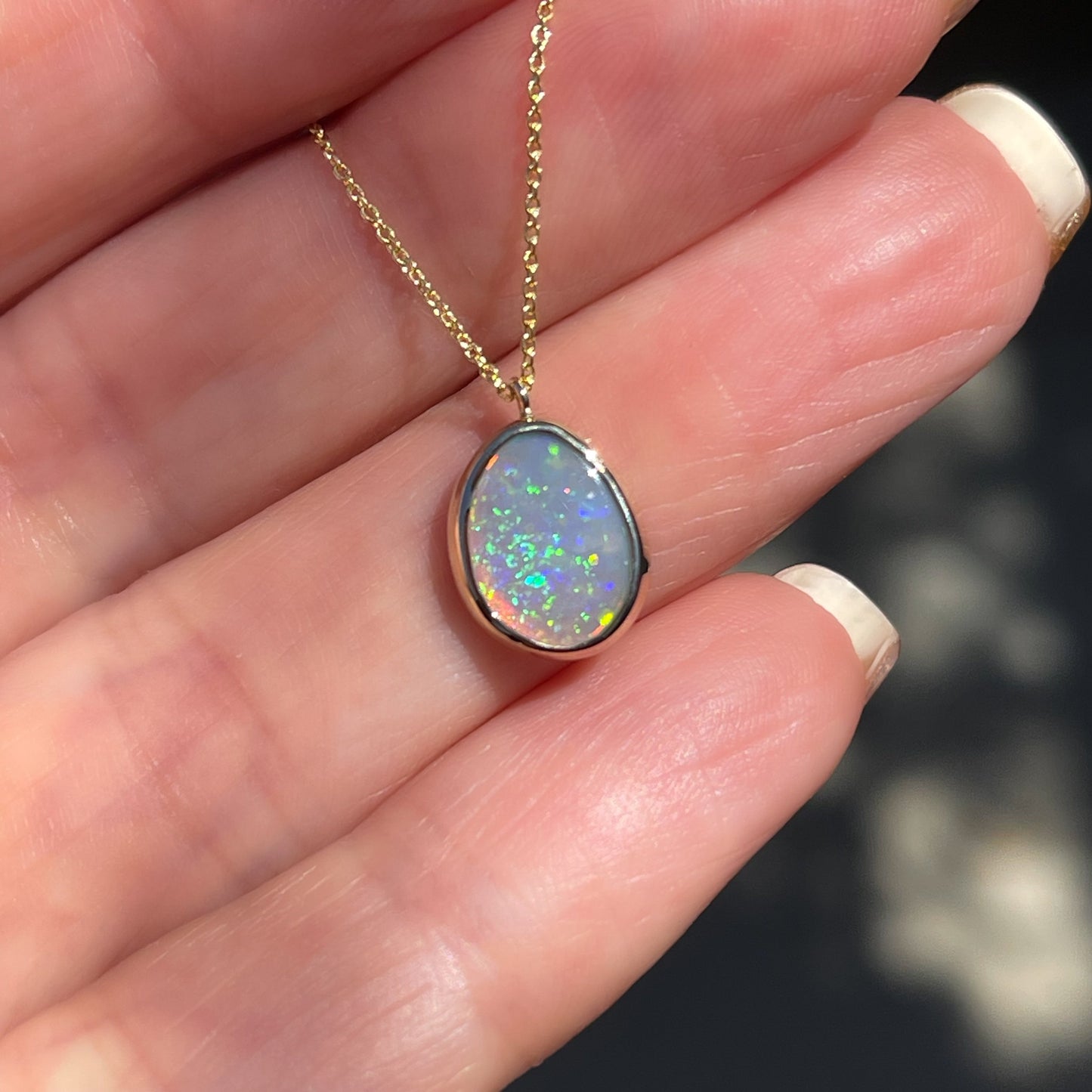 An Australian Opal Necklace by NIXIN Jewelry. A gold opal necklace with a black opal stone.