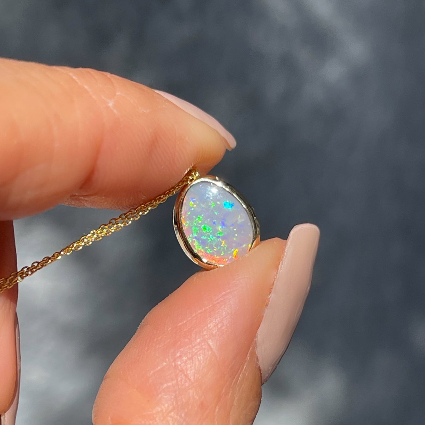 An Australian Opal Necklace by NIXIN Jewelry.  An opal pendant with a black opal stone set in yellow gold.