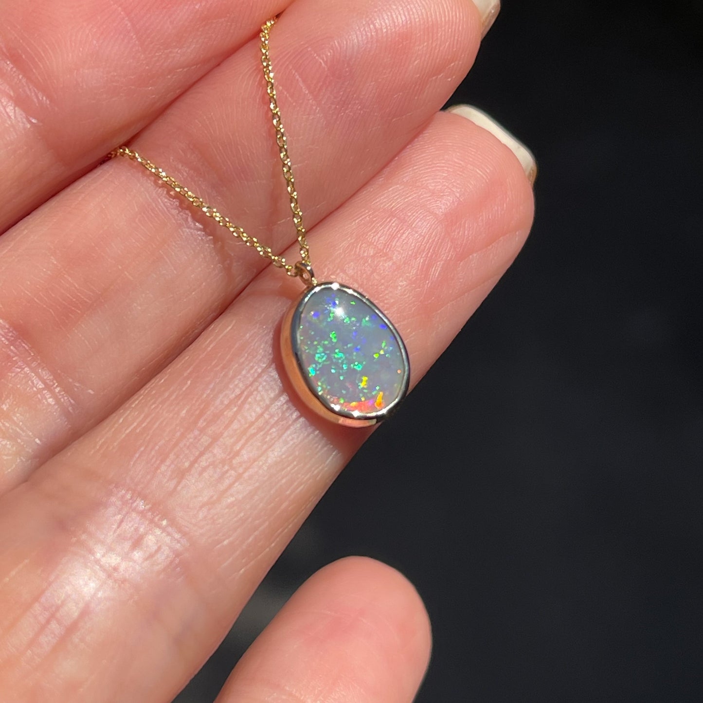 Angled shot of an Australian Opal Necklace by NIXIN Jewelry. Shows the wall of the bezel setting. 