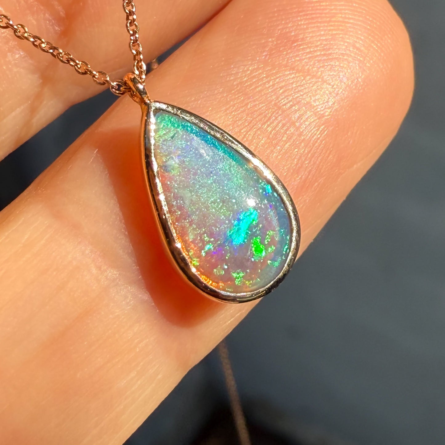 An Australian Opal Necklace by NIXIN Jewelry emphasizing the teardrop opal stone and its brilliant art quality. This ultra-close shot captures the fine detail and spectral color transitions of this crystal opal, appealing to customers searching for premium rare jewelry. This women's luxury necklace is a unique investment piece.