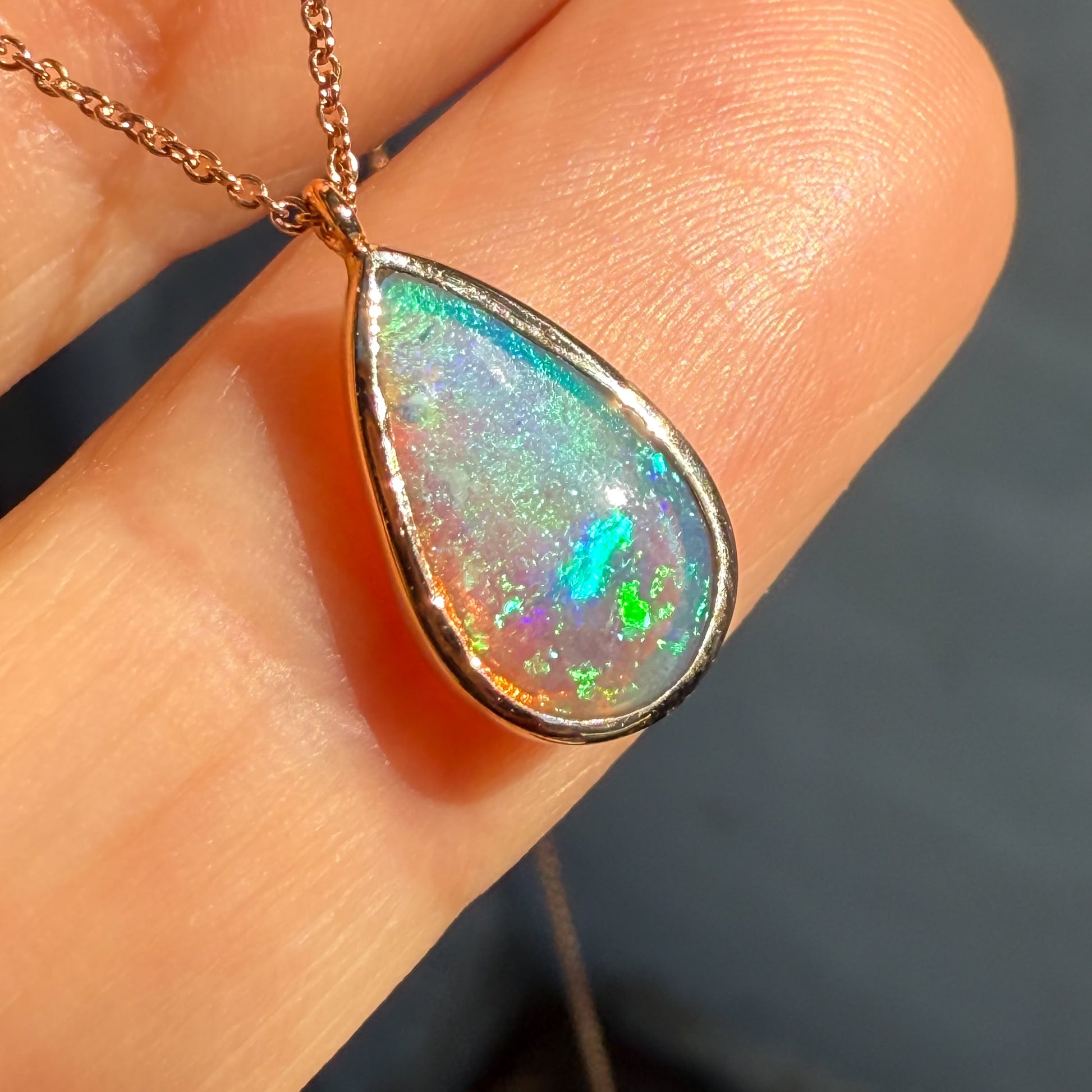 An Australian Opal Necklace by NIXIN Jewelry emphasizing the teardrop opal stone and its brilliant art quality. This ultra-close shot captures the fine detail and spectral color transitions of this crystal opal, appealing to customers searching for premium rare jewelry. This women's luxury necklace is a unique investment piece.