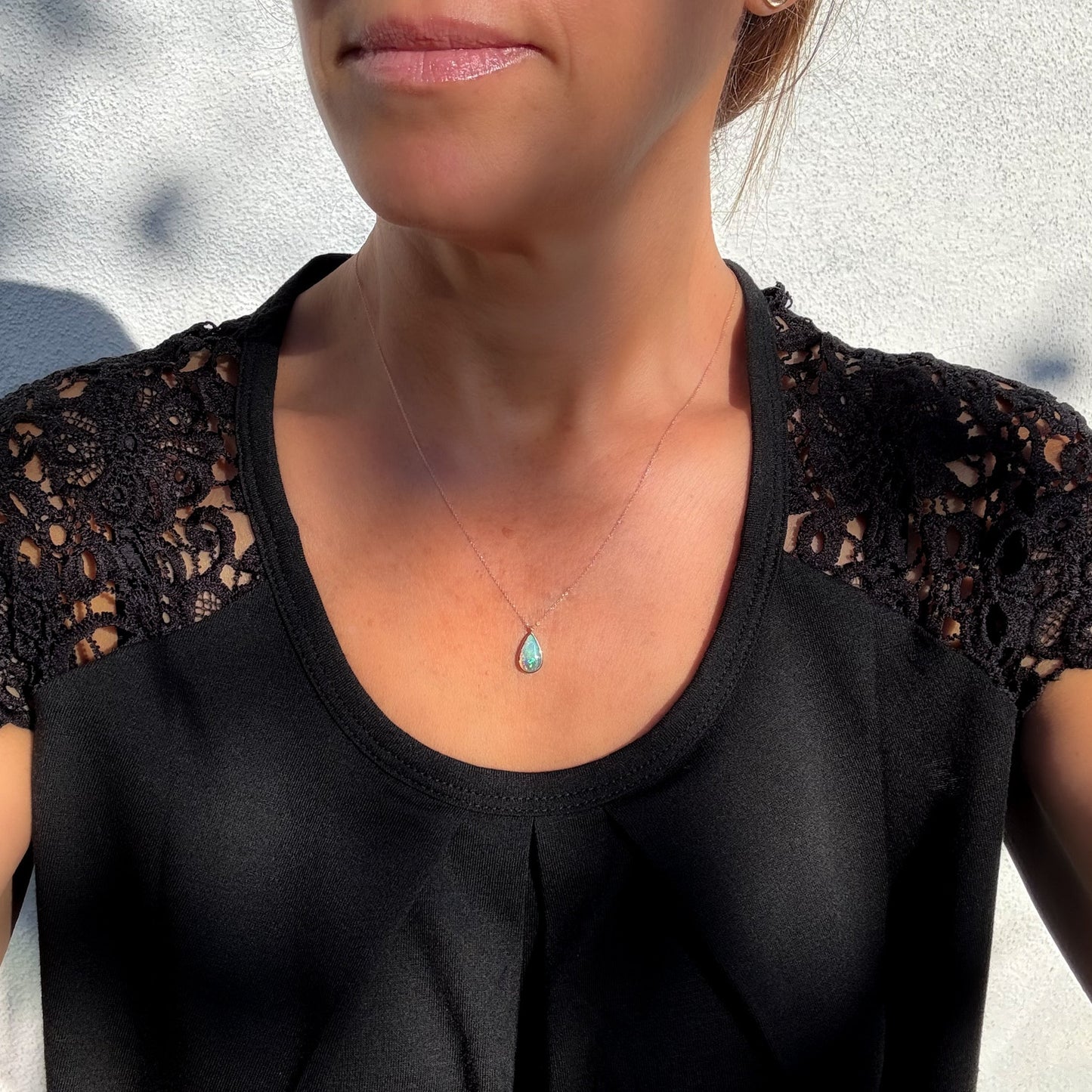 An Australian Opal Necklace by NIXIN Jewelry worn by a model to showcase the scale and elegant fit of the rose gold opal necklace on the neckline. This women's luxury necklace is a perfect statement piece for high-end luxury buyers interested in handmade jewelry designs. The opal necklace size is ideal for daily wear.