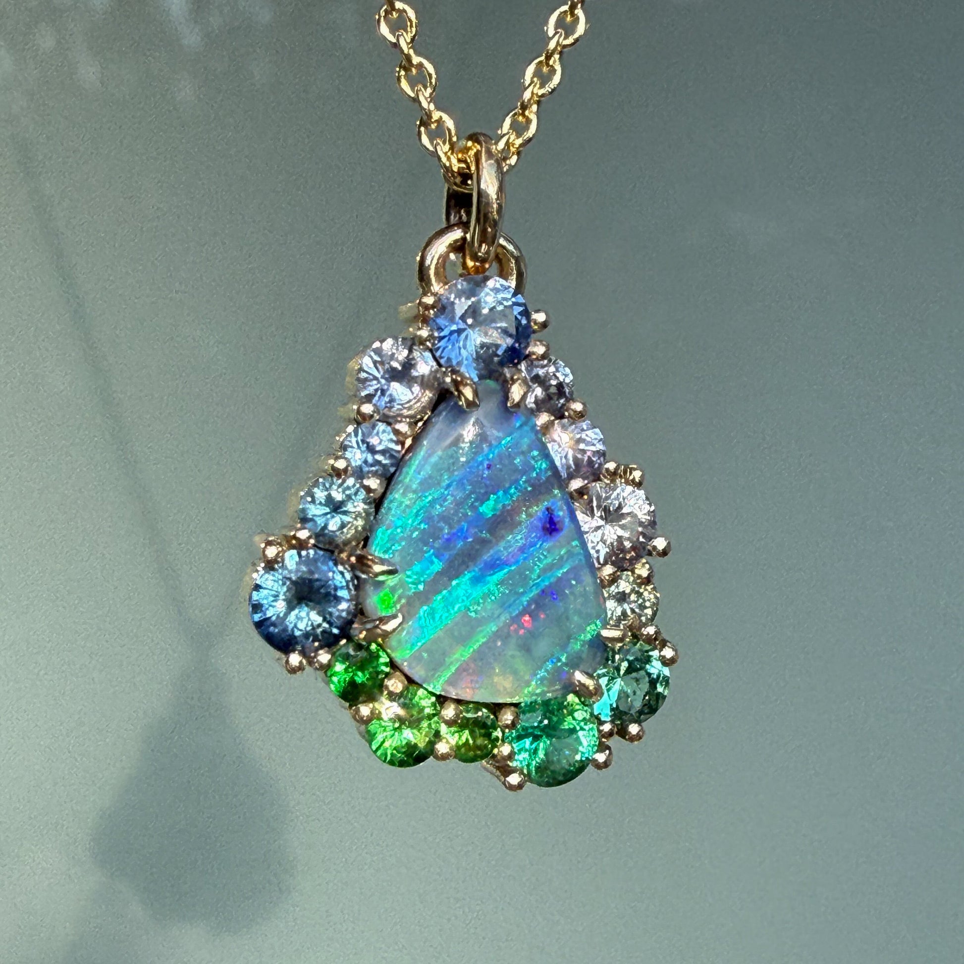 A detailed close-up of an Australian Opal Necklace by NIXIN Jewelry reveals the intricate prongs that hold the gemstones in place. This gold opal necklace is a prime example of luxury jewelry, blending natural Australian opal with high-end sapphire necklace details.