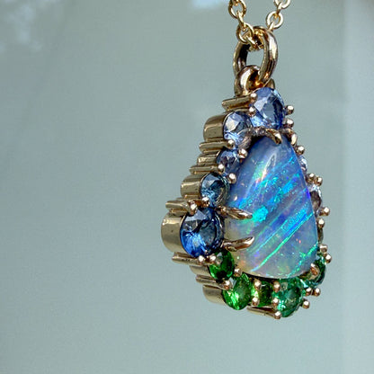 The side profile of an Australian Opal Necklace by NIXIN Jewelry displays the depth of the polish gold setting and the secure prong setting. This women's luxury necklace is designed as a piece of jewelry art that is both durable and elegant.
