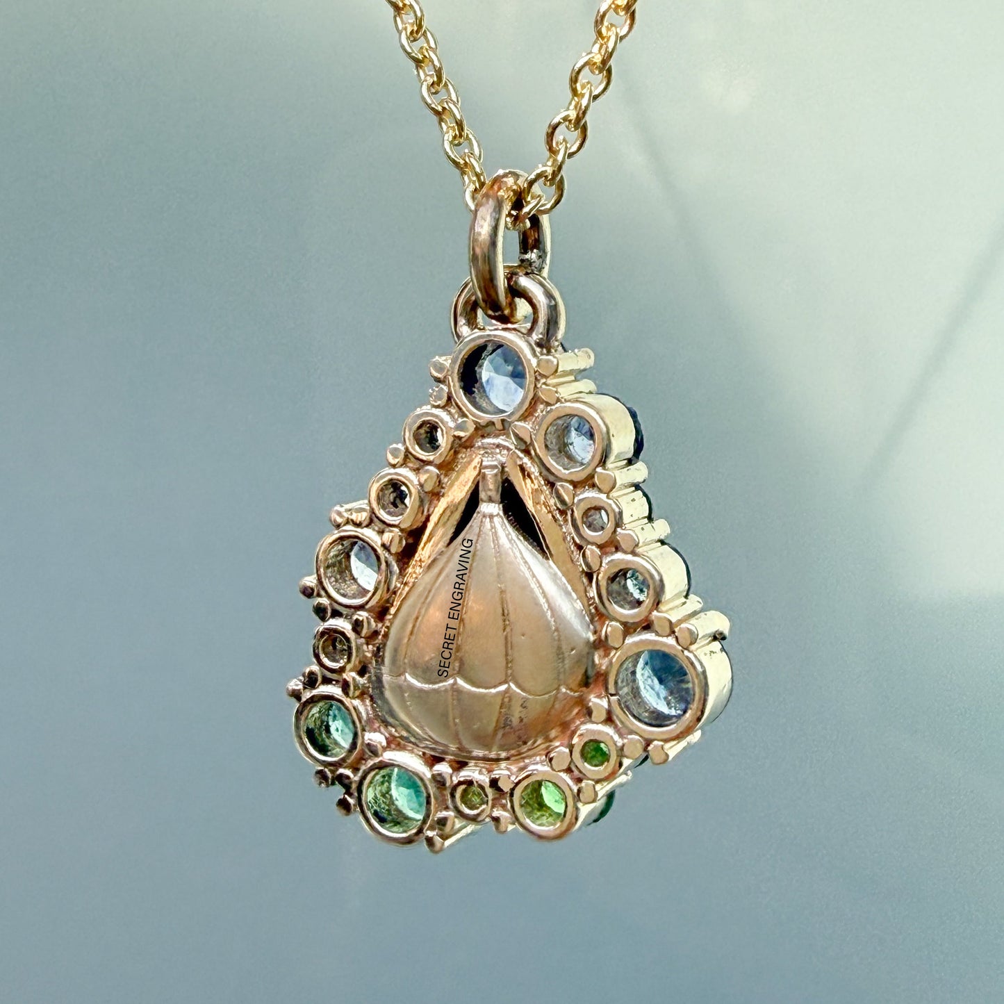 This view shows the back of an Australian Opal Necklace by NIXIN Jewelry, featuring a custom secret engraving on the solid gold setting. The finish on the gold reflects the meticulous craftsmanship of this unique fine jewelry piece.