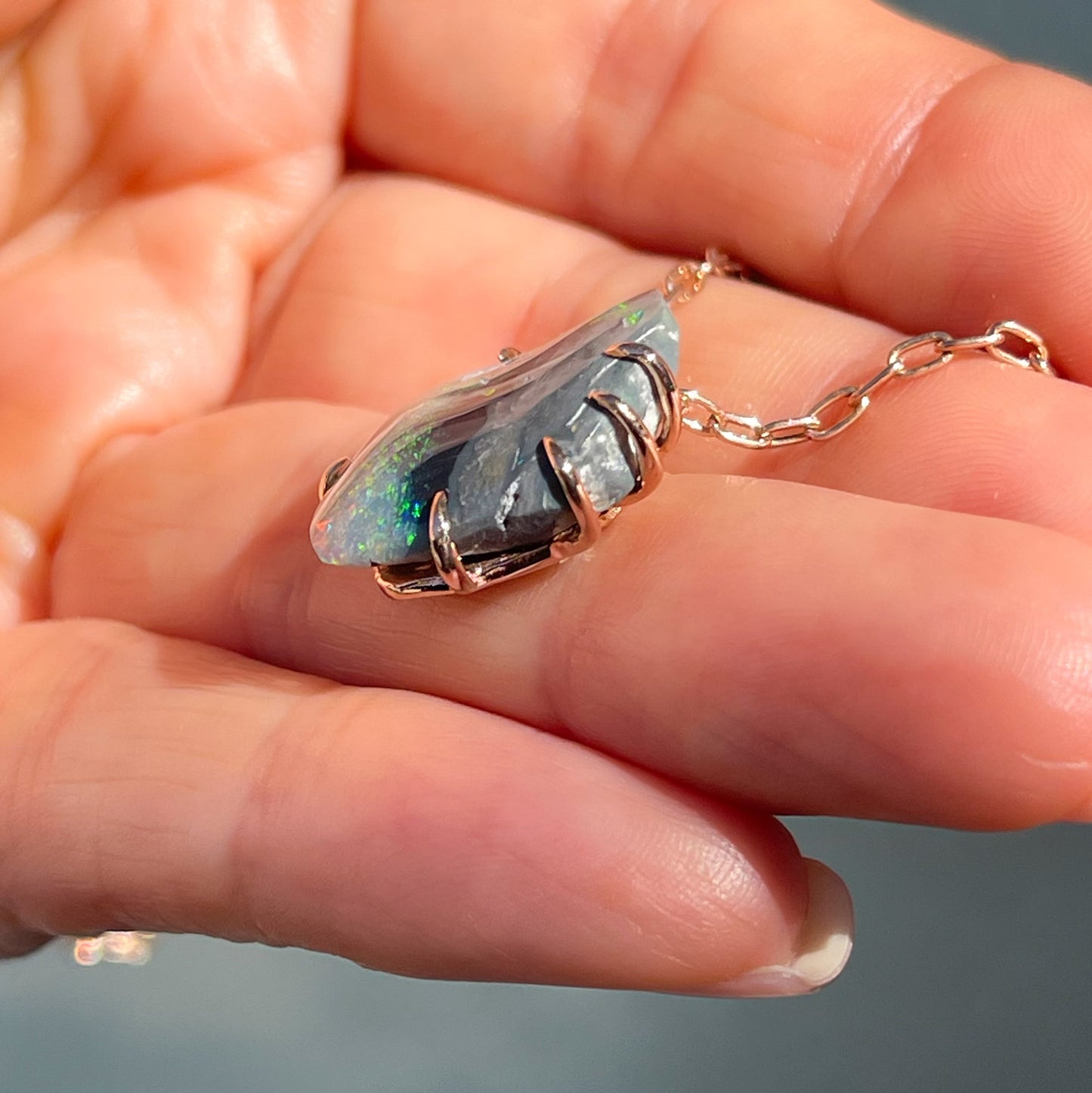 Side view of an Australian Opal Necklace showing claw prongs around a Black Opal.