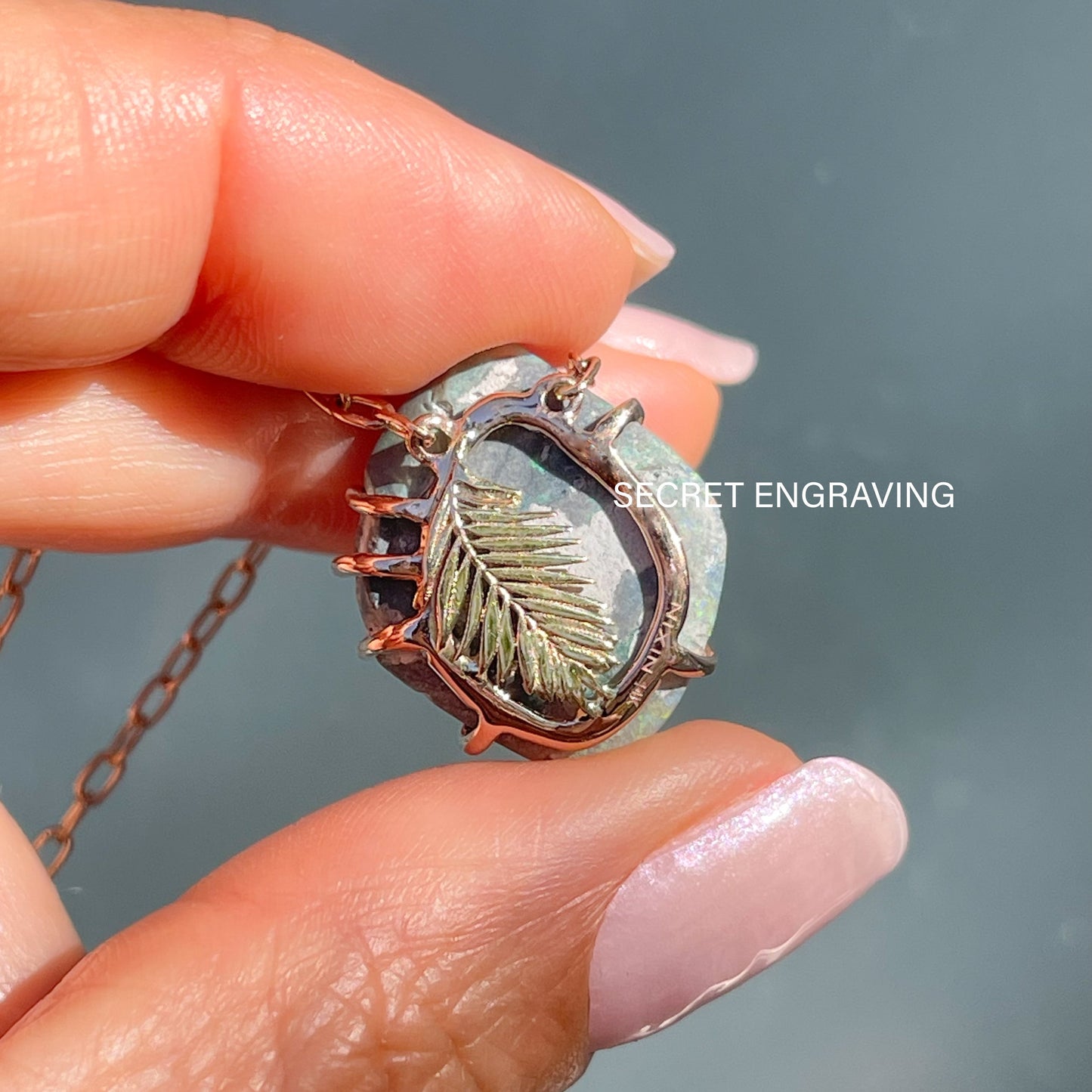 Back view of an Australian Opal Necklace showing the rose gold mounting and a yellow gold palm frond.