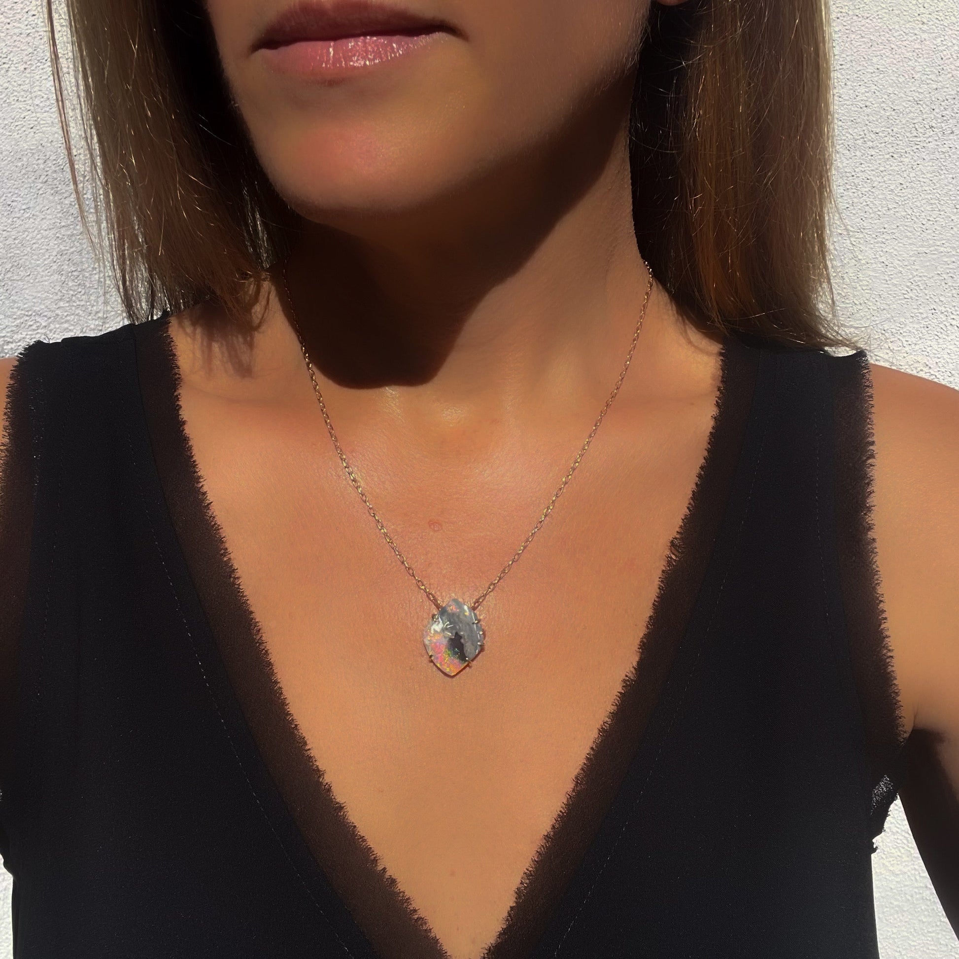 Model wearing an Australian Opal Necklace by NIXIN Jewelry set in rose gold. A unique opal necklace.