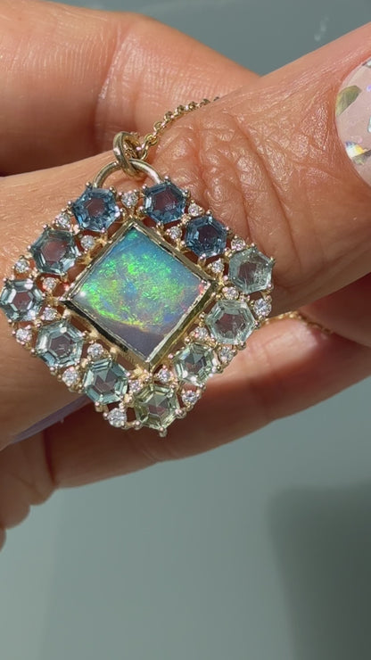 A video demonstration highlights the dynamic color shifts of an Australian Opal Pendant by NIXIN Jewelry as it moves through the light. The luxury black opal necklace features a rare lightning ridge opal in a gold bezel setting, bordered by an ombre halo of hexagon-cut montana sapphires and prong-set diamonds. The footage also turns to capture the reverse side, showcasing a structural honeycomb latticework that elevates this piece of unique fine jewelry into a work of wearable jewelry art.