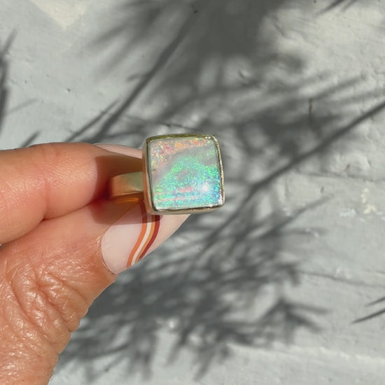 An Australian Opal Ring by NIXIN Jewelry, captured in motion. See the incredible play of light in this rare black opal ring, a true piece of luxury jewelry art.