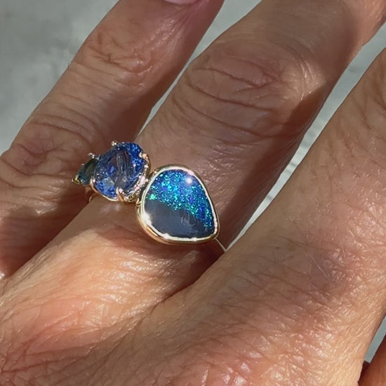 This video showcases an Australian Opal Ring by NIXIN Jewelry — a one-of-a-kind gold opal ring blending deep hues of a natural black opal with the cool tones of sapphires and emerald. This piece of luxury jewelry is a prime example of rare jewelry, perfect for those seeking a women's luxury ring.