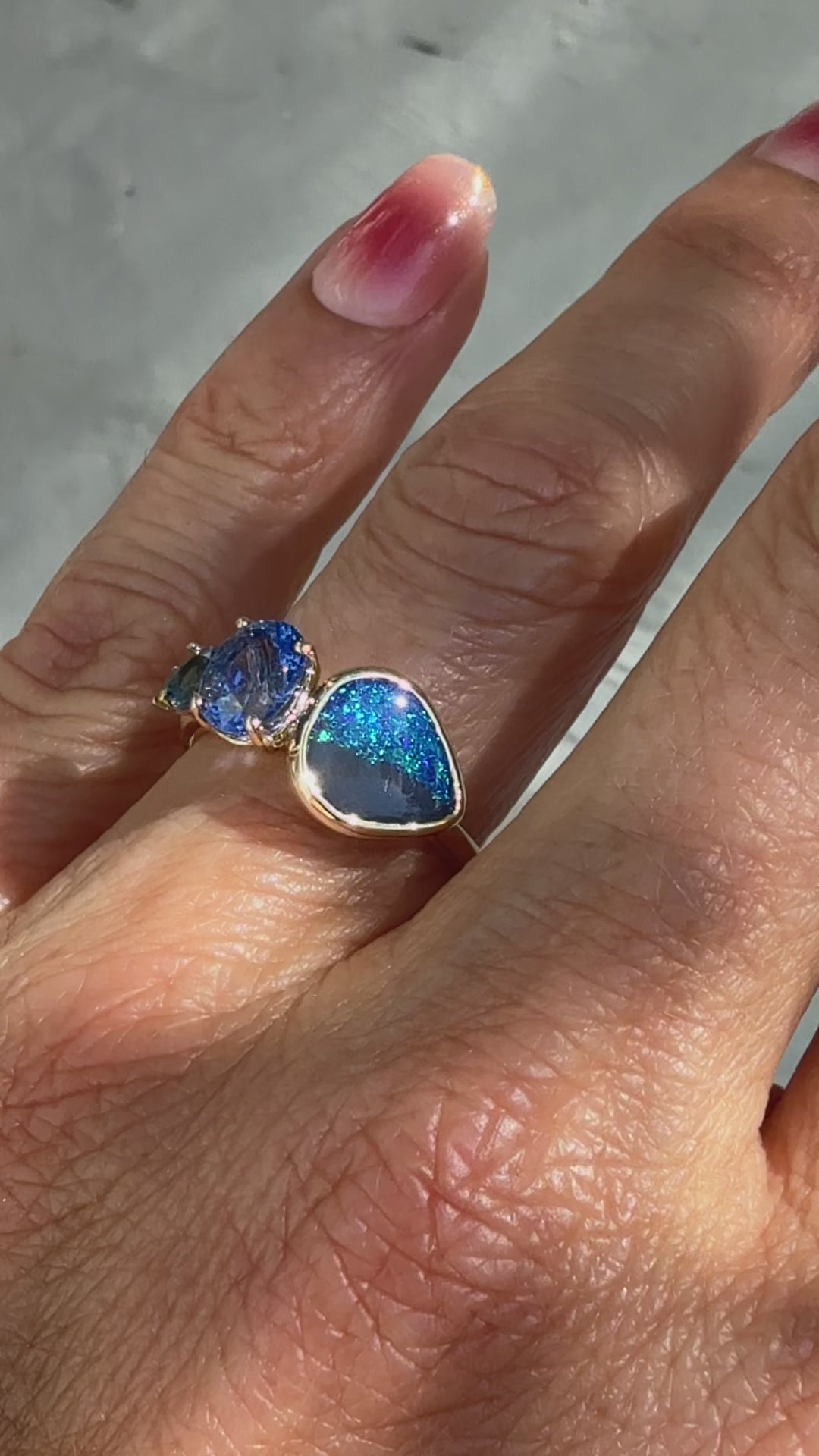 This video showcases an Australian Opal Ring by NIXIN Jewelry — a one-of-a-kind gold opal ring blending deep hues of a natural black opal with the cool tones of sapphires and emerald. This piece of luxury jewelry is a prime example of rare jewelry, perfect for those seeking a women's luxury ring.