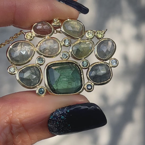 Video of a Tourmaline and Sapphire Necklace by NIXIN Jewelry with green gemstones bezel set in gold.