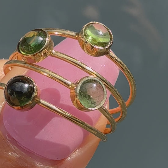 Lucky Green Tourmaline Rings turning in sunlight, four green tourmaline cabochon stacking rings in 14k gold.