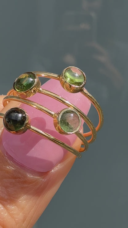 Lucky Green Tourmaline Rings turning in sunlight, four green tourmaline cabochon stacking rings in 14k gold.