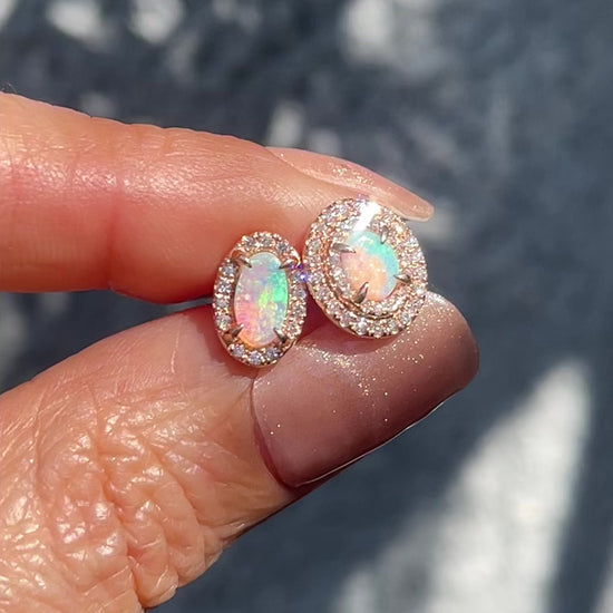 Video of Australian Opal Earrings by NIXIN Jewelry held in sunlight to show the fire of the opal stud earrings.