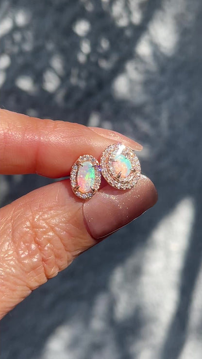 Video of Australian Opal Earrings by NIXIN Jewelry held in sunlight to show the fire of the opal stud earrings.
