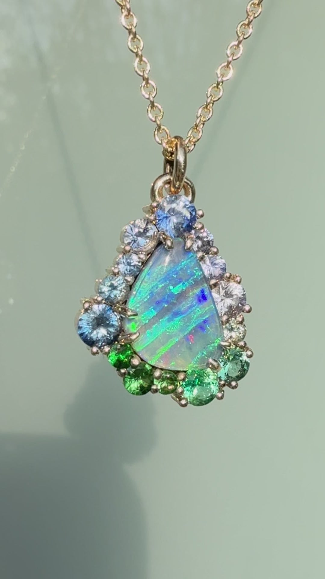 This video showcases an Australian Opal Necklace by NIXIN Jewelry, highlighting the vivid play-of-color in a natural opal necklace. The unique fine jewelry features a stunning ombre effect using a sapphire halo secured in a gold prong setting. This women's luxury necklace is a stunning example of high jewelry, making it a truly unique opal pendant for any luxury jewelry collection.