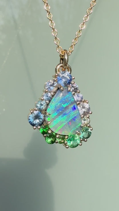 This video showcases an Australian Opal Necklace by NIXIN Jewelry, highlighting the vivid play-of-color in a natural opal necklace. The unique fine jewelry features a stunning ombre effect using a sapphire halo secured in a gold prong setting. This women's luxury necklace is a stunning example of high jewelry, making it a truly unique opal pendant for any luxury jewelry collection.