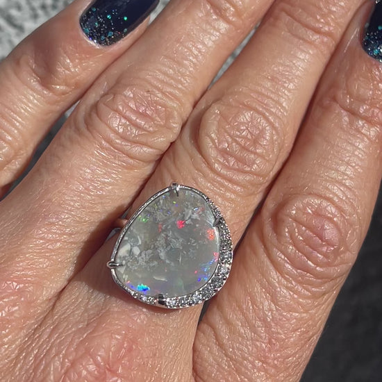 Video of an Australian Opal Ring by NIXIN Jewelry worn in the sun. The opal ring with diamonds is made in 14k white gold.