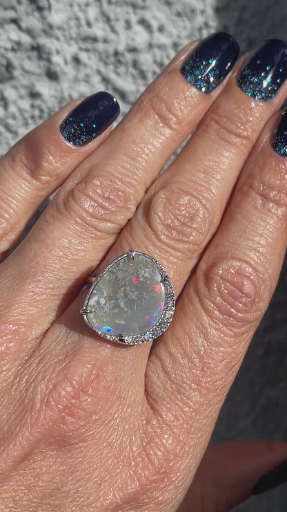 Video of an Australian Opal Ring by NIXIN Jewelry worn in the sun. The opal ring with diamonds is made in 14k white gold.