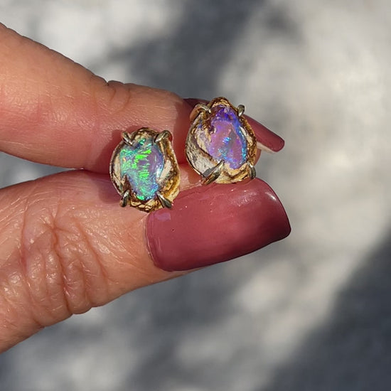 Video of a pair of Australian Opal Earrings by NIXIN Jewelry held in sunlight. Shows the flashing colors of the luxury earrings.