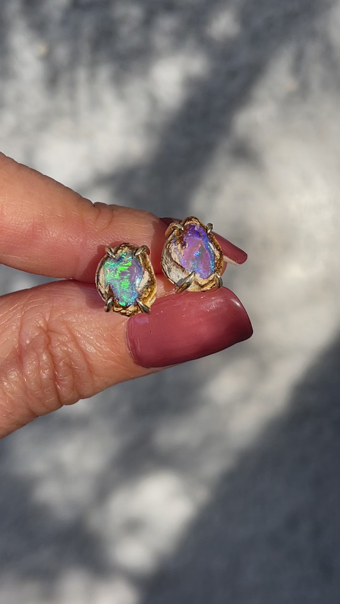 Video of a pair of Australian Opal Earrings by NIXIN Jewelry held in sunlight. Shows the flashing colors of the luxury earrings.