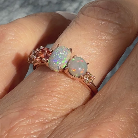 An Australian Opal Ring by NIXIN Jewelry shown in motion, capturing the dramatic fire and color transition of the sapphire opal ring. The video highlights the unique semi black opal patterns (pinfire and flash) amplifying the peach ombre sapphire gradient. This luxury ring video is critical for showing the true depth of the rare opal jewelry.