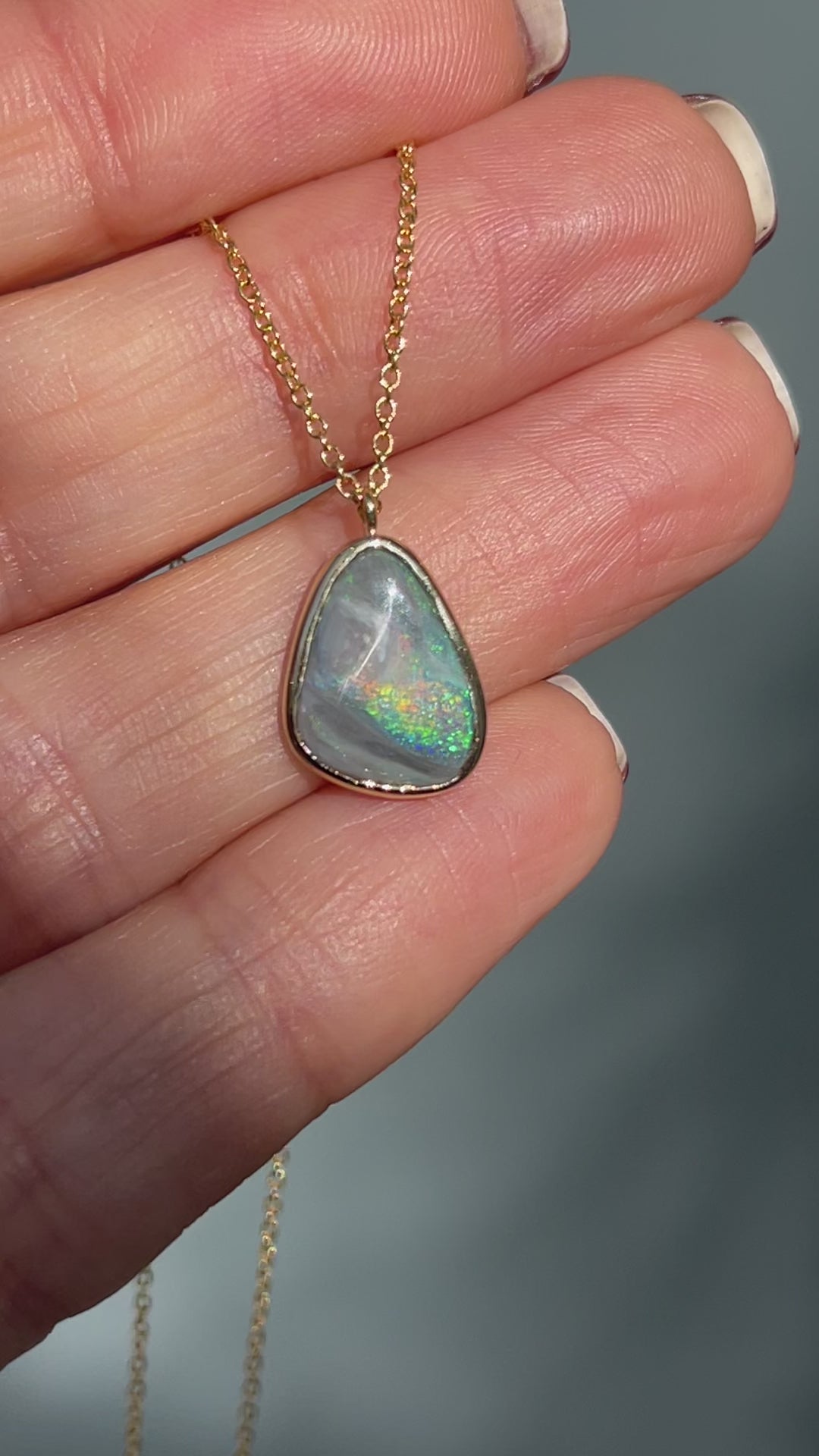 Video of an Australian Opal Necklace by NIXIN Jewelry moving in the sunlight. The Black opal necklace is set in gold.