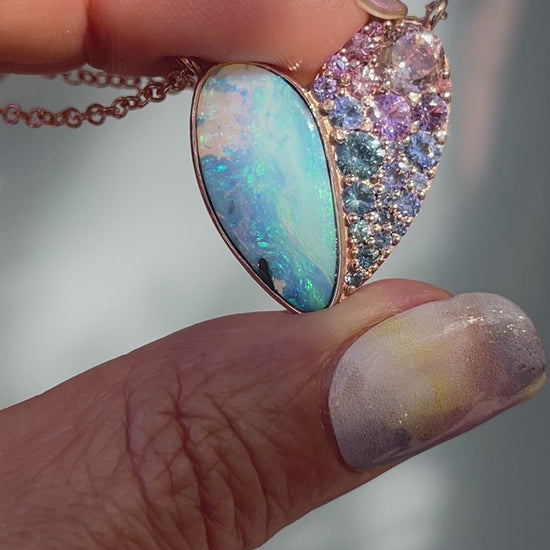 Video of a Heart Opal Necklace by NIXIN Jewelry with a Boulder Opal and sapphires set in rose gold.