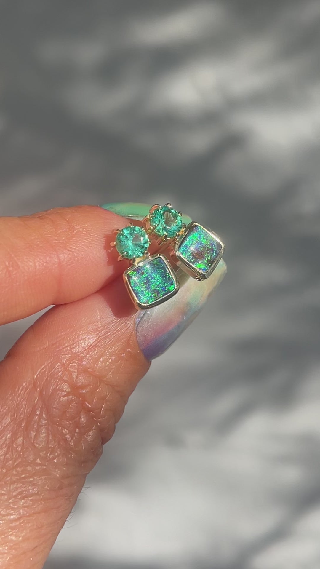 Video of Australian Opal Earrings by NIXIN Jewelry. Shows the vibrant boulder opals and the emeralds in the sunlight.
