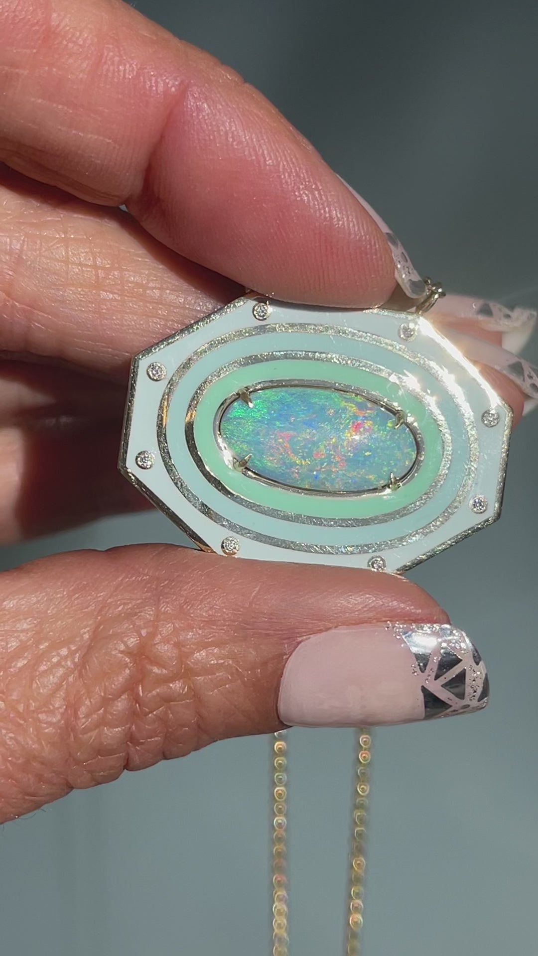 Video of an Australian Opal Necklace by NIXIN Jewelry. Shows the natural opal against the beauty of an enamel necklace.