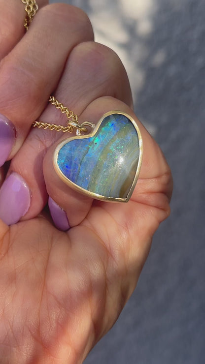 Video of an Australian Opal Necklace by NIXIN Jewelry with an opal heart set in a matte gold bezel.