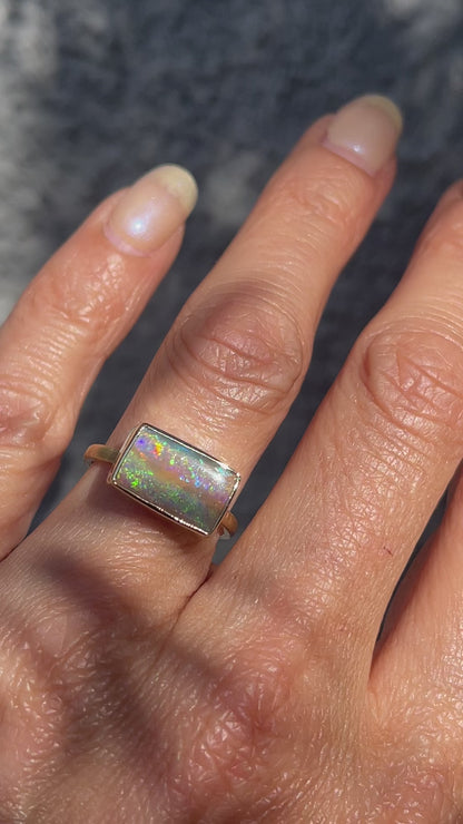 An Australian Opal Ring by NIXIN Jewelry modeled for scale with a Pipe Opal set in 14k gold.
