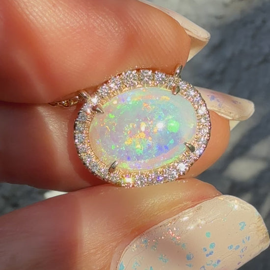 Video of an Australian Opal Necklace by NIXIN Jewelry, displaying the dynamic color shift of the crystal opal as it moves in natural light. This luxury jewelry video highlights the brilliance of the diamond halo and the mesmerizing nature of the unique opal pendant. The perfect representation of a rare opal necklace.