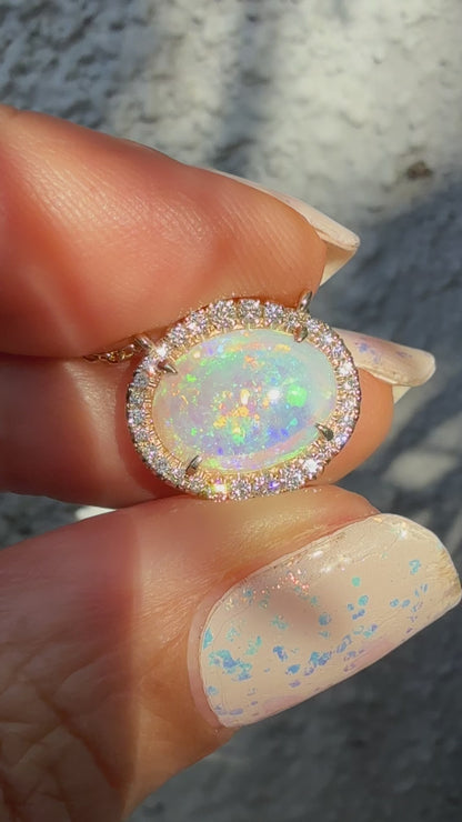 Video of an Australian Opal Necklace by NIXIN Jewelry, displaying the dynamic color shift of the crystal opal as it moves in natural light. This luxury jewelry video highlights the brilliance of the diamond halo and the mesmerizing nature of the unique opal pendant. The perfect representation of a rare opal necklace.