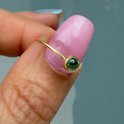Lucky Green Tourmaline Ring in mint green, a single tourmaline cabochon in a 14k gold bezel, shown at an angle.