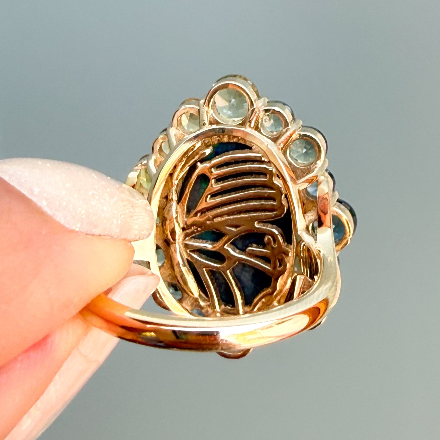 Back side of an Australian Opal Ring by NIXIN Jewelry, displaying a hidden gallery. This gold opal ring is made of 14k gold. The rare Australian opal is an investment in wearable art.