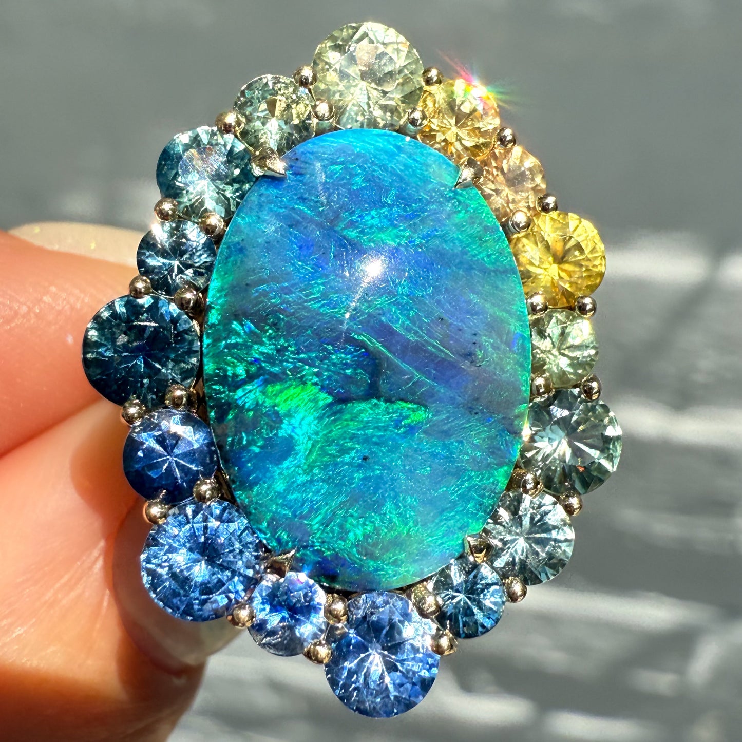 An Australian Opal Ring by NIXIN Jewelry. This black opal jewelry piece is a stunning example of unique fine jewelry. The hues of the blue opal are captivating as a centerpiece for this luxury ring.