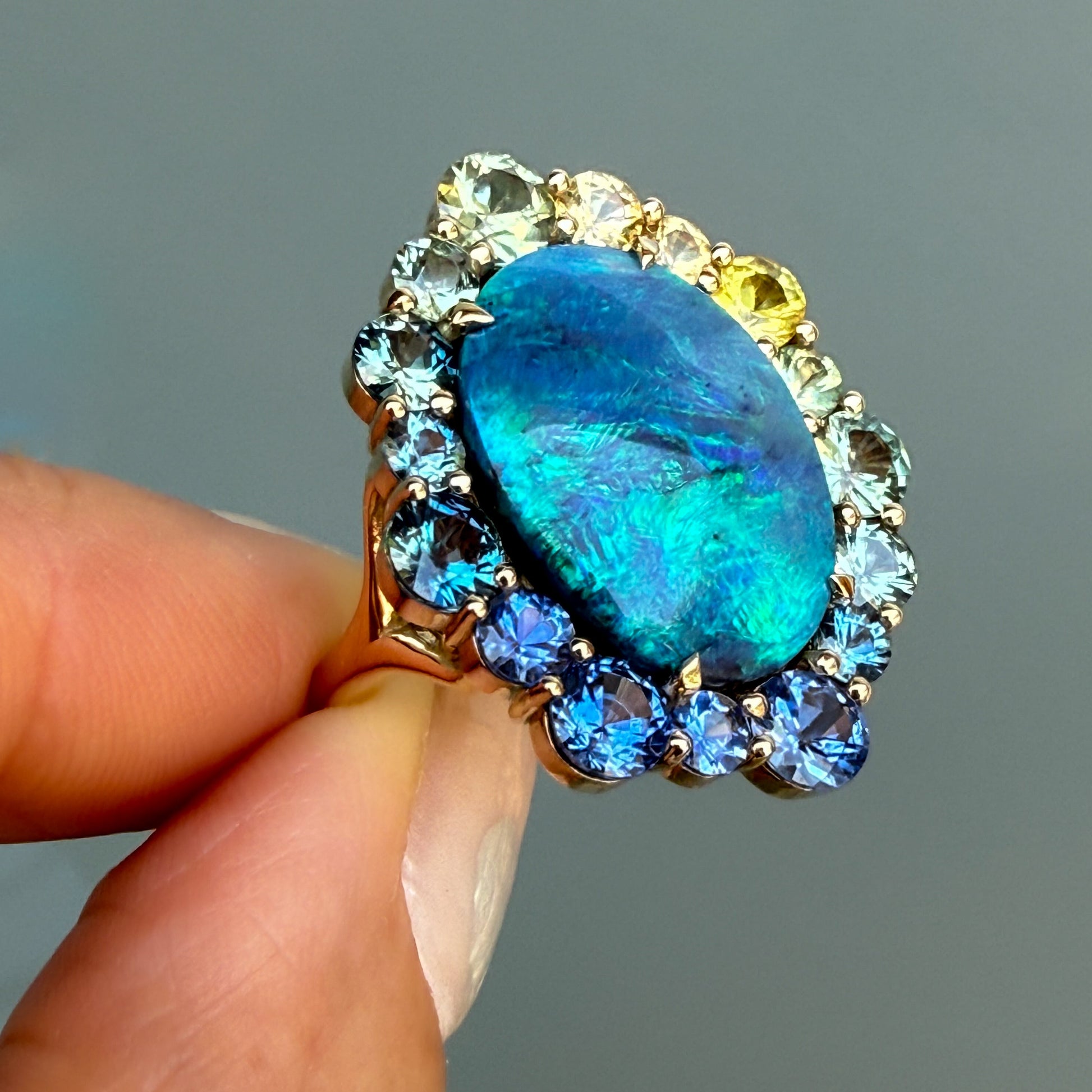Angled shot of an Australian Opal Ring by NIXIN Jewelry. This gold opal ring is a one-of-a-kind creation from Lightning Ridge opal. It is a piece of jewelry art that highlights the beauty of natural opal.
