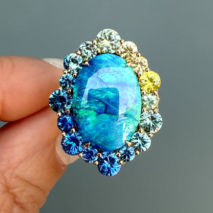 An Australian Opal Ring by NIXIN Jewelry held in shade. This modern opal ring is made with a black opal. It is a luxury jewelry piece designed to make a statement.