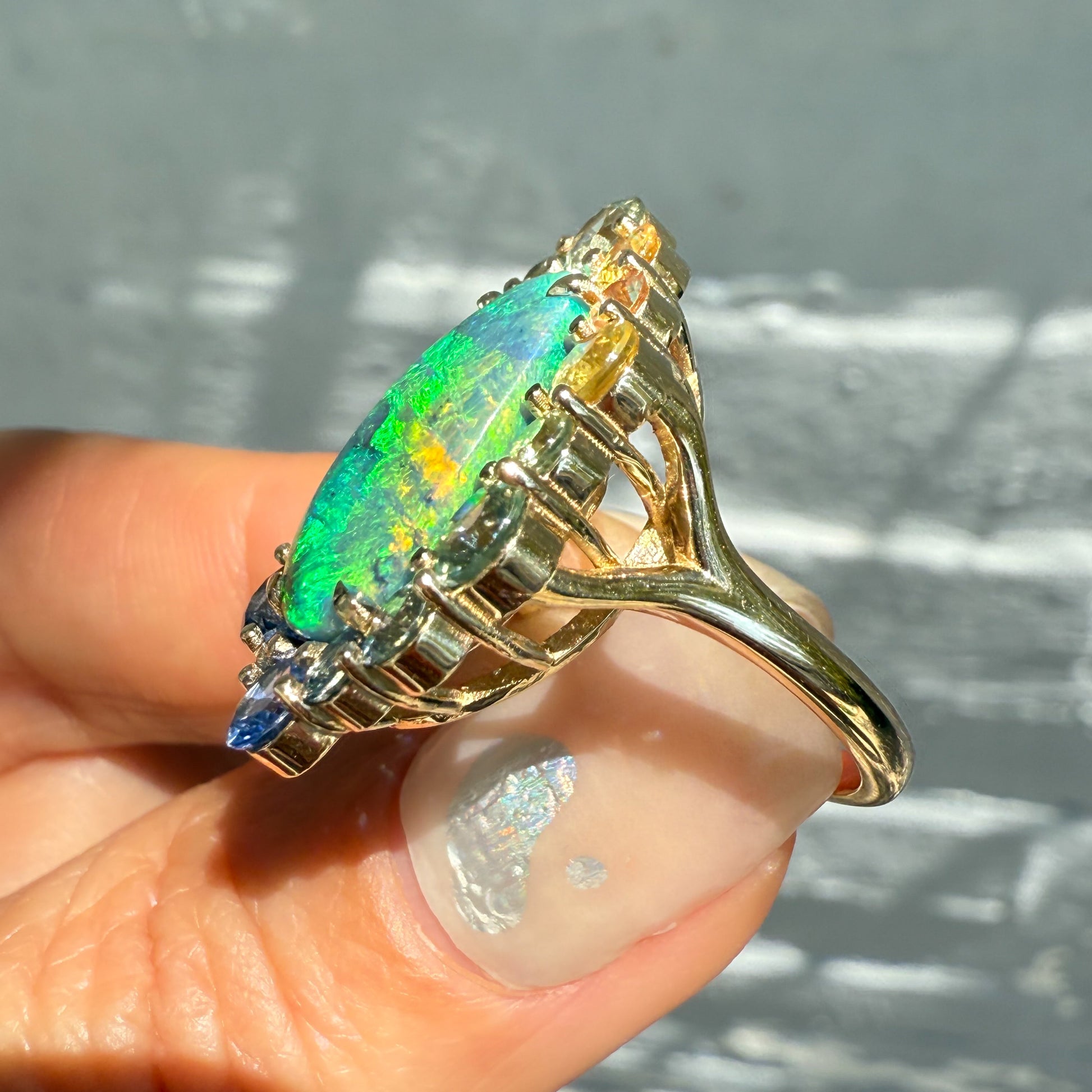 Side view of an Australian Opal Ring by NIXIN Jewelry. This luxury ring is set in gold and features a striking black opal. The unique design and high-quality craftsmanship make it a piece of wearable art.