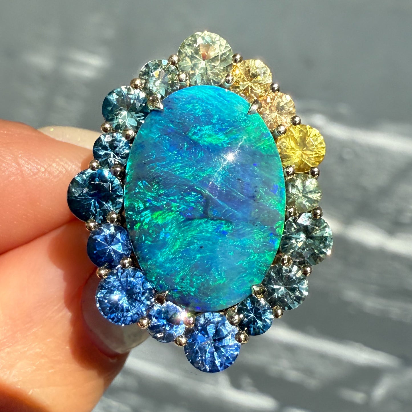An Australian Opal Ring by NIXIN Jewelry. This luxury ring showcases a blue opal in a prong setting. The design is a true work of jewelry art.