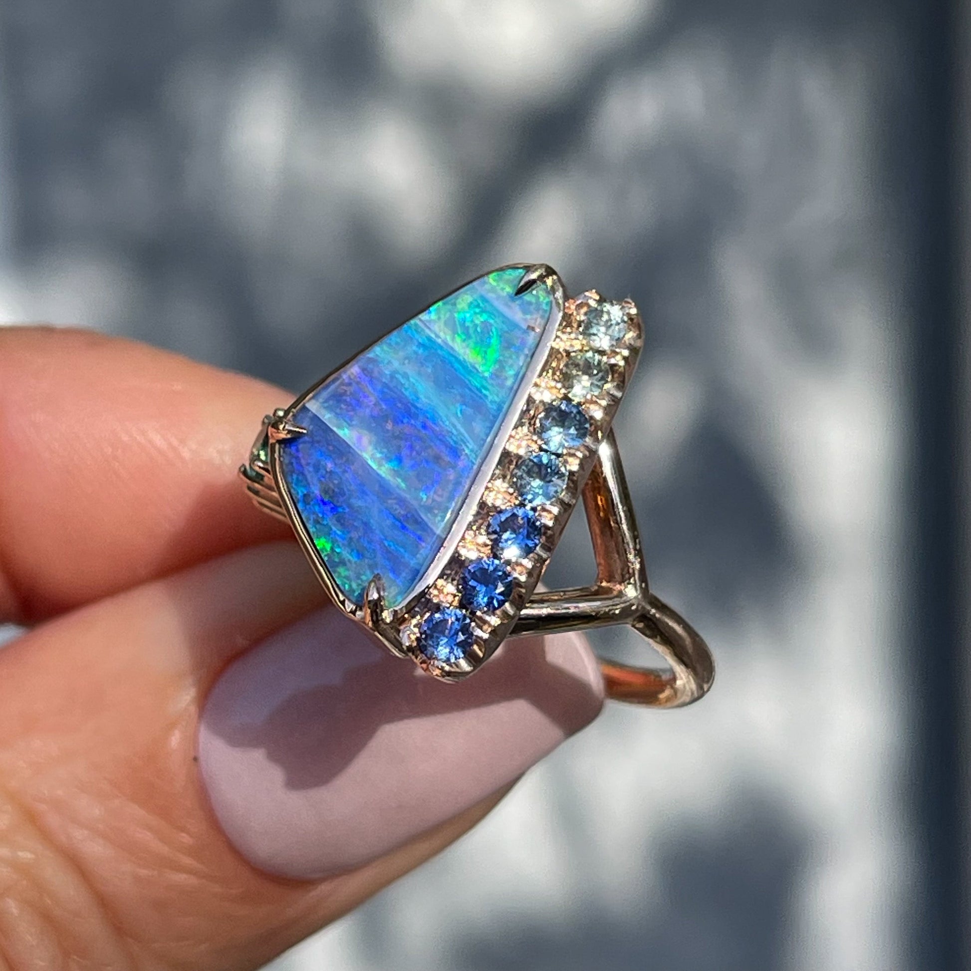 Side view of an Australian Opal Ring by NIXIN Jewelry showing sapphires in pave setting.
