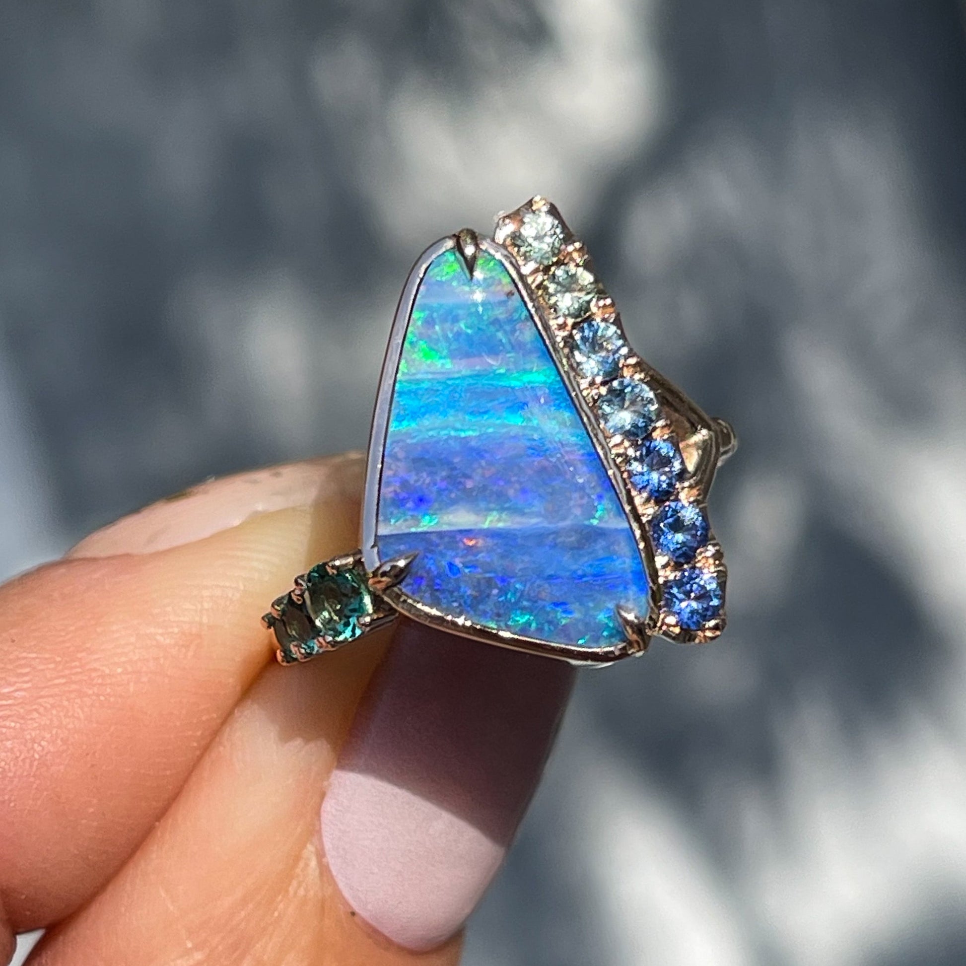 An Australian Opal Ring by NIXIN Jewelry. The opal and sapphire ring also has emeralds.