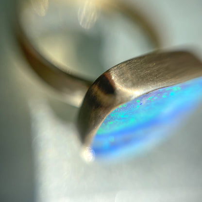 Angled shot of an Australian Opal Ring by NIXIN Jewelry. Shows the bezel setting around the opal stone.