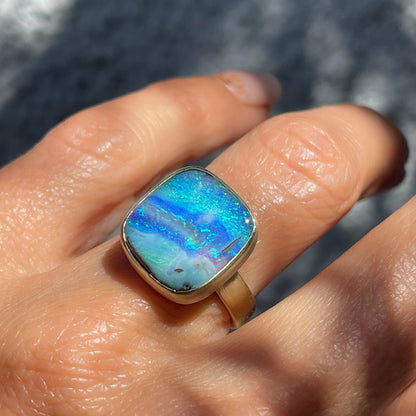 An Australian Opal Ring by NIXIN Jewelry modeled on a hand. A unique opal ring.