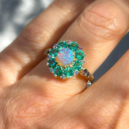 An Australian Opal Ring by NIXIN Jewelry with a black opal center. The opal and emerald ring is 14k gold.